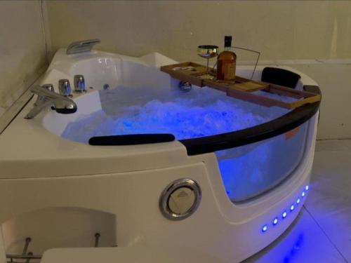a bath tub with blue water in a bathroom at 5 Start luxury rooms with presidential Comfort well equipped in Limbe