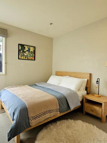 a bedroom with a large bed and a table at Lilypad of Three Kings Guest Rooms in Auckland