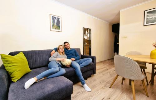 a man and a woman sitting on a couch at SeaShell Studio Przymorze in Gdańsk