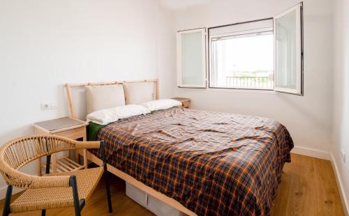 una piccola camera da letto con un letto e una finestra di Doñana Loft 17 a Sanlúcar de Barrameda