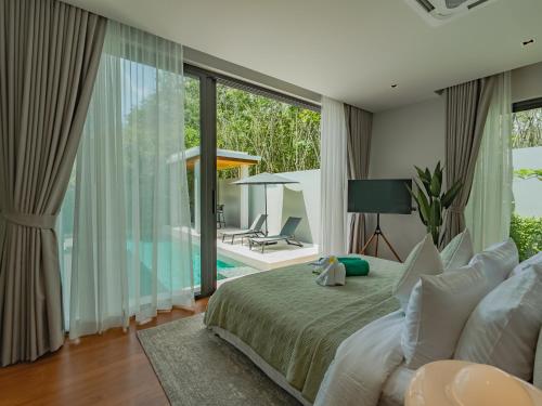 ein Schlafzimmer mit einem Bett und Blick auf einen Pool in der Unterkunft NEW Cozy 3BR Luxury Pool Villa - Villa Nova in Ban Pak Lak
