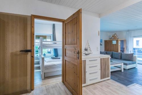 Zimmer mit einem Schlafzimmer mit einem Bett und einer Tür in der Unterkunft CBlue "Kaptain Carl", Terrasse, Grill, Strandnah in Graal-Müritz