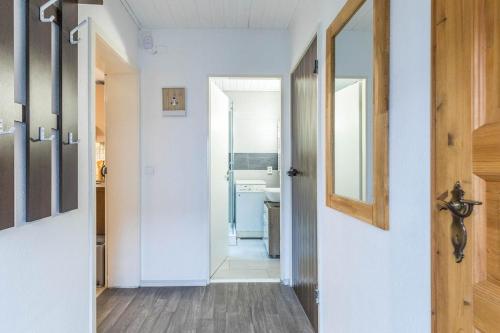 einen Flur mit Tür zum Bad in der Unterkunft CBlue "Kaptain Carl", Terrasse, Grill, Strandnah in Graal-Müritz