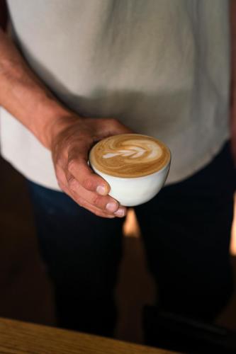 Un uomo sta reggendo una tazza di caffè di Loop - K1 Treehouses a Odenthal