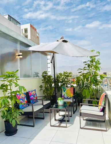 a patio with chairs and an umbrella on a roof at Bon Repos Arequipa in Arequipa