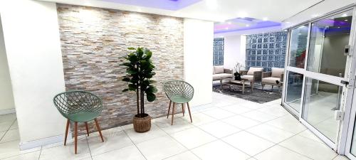 a lobby with two chairs and a plant at Tenbury by the beachfront 806 in Durban