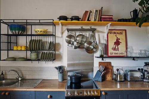 a kitchen with a sink and a stove and shelves at Mid-Century charm in the heart of Stroud in Stroud