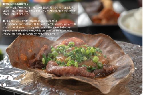 un pacchetto di cibo con carne e cipolle verdi di Ryokan Gizan a Takayama