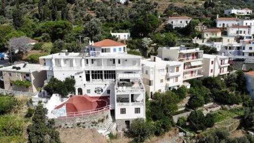 a large white building on top of a hill at Bluenigma Hotel 5 in Andros