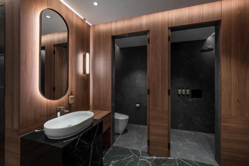 Un baño con inodoro, lavabo y espejo. en Citadines Connect Bertam Georgetown Penang, en George Town