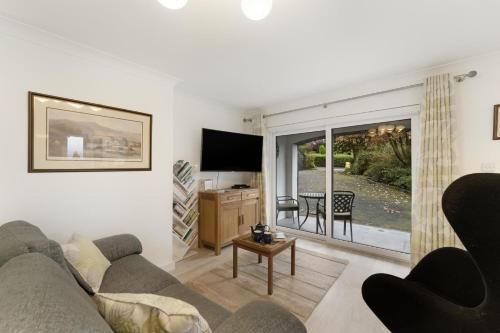 a living room with a couch and a television at Fisherbeck Nest in Ambleside