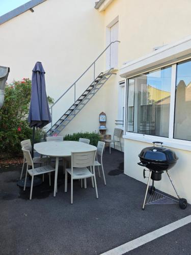 een patio met een grill en een tafel en stoelen bij La maison du temps suspendu in Menetou-Râtel