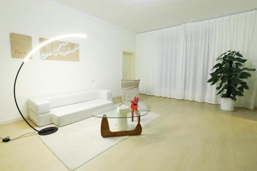 a living room with a white couch and a table at 贵阳方得其所民宿 in Kweichu