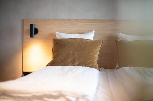 a bed with white sheets and pillows in a room at Hotel Djurhuus in Tórshavn