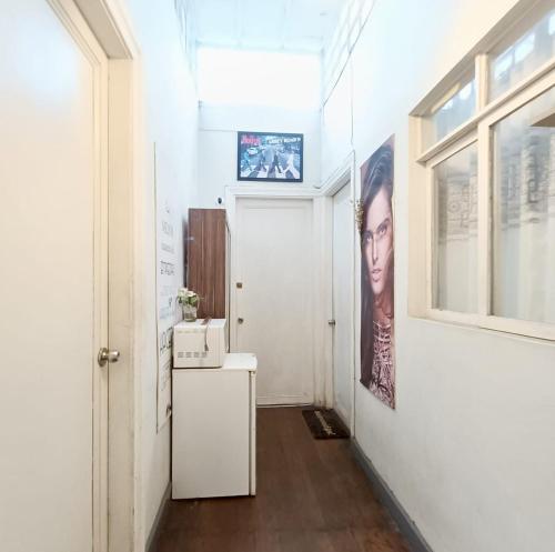 a hallway with a white wall with a picture of a woman at Casa Turística Monumental in Lima