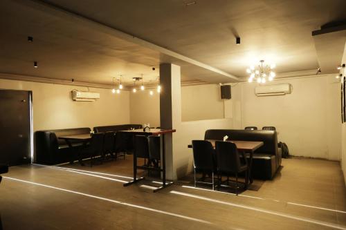 a dining room with tables and chairs and lights at Serene Stays in Chennai