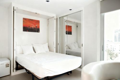 a white bedroom with a bed and a sink at 芭提雅瞰海无边泳景泳池健身房公寓 直达海滩椰子树旁 in Pattaya South