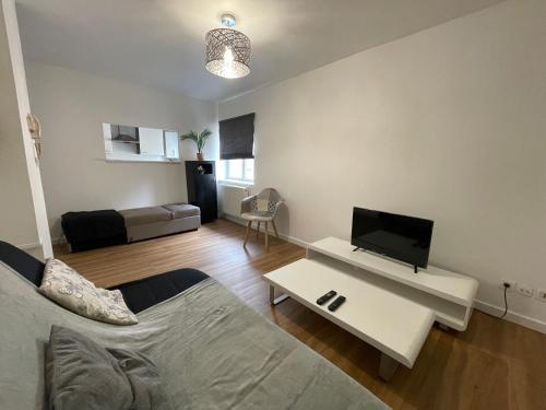a living room with a couch and a tv at Vue sur Saint Quentin Un Séjour à Part in Longeville-lès-Metz