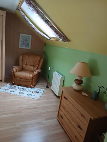a living room with a chair and a lamp on a dresser at Chez Mayayoya 