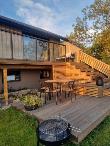 a house with a wooden deck with a table and chairs at House by the fjord in Vadsø