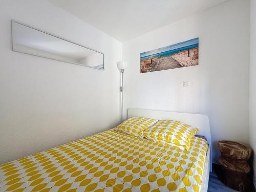 ein Schlafzimmer mit einem Bett mit gelber Decke in der Unterkunft Le Muge - Appartement Rez-de-chaussée - Piscine in Narbonne-Plage