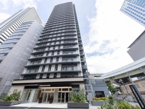 a tall building in the middle of a city at Brackets Hotel Osaka Hommachi in Osaka