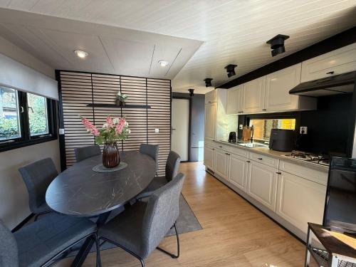 a kitchen and dining room with a table and chairs at VELUWE VOORTHUIZEN COMFORTABLE CHALET - Comfortable Chalet with Good Amenities and several Activities for Families and Tourists nearby in Voorthuizen