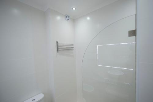 Baño blanco con cabina de ducha de cristal en Apartamentos Tio Papel II, en Albufeira
