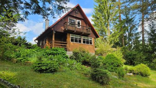 a wooden house with a gambrel roof at Chata Babča in Jetřichovice