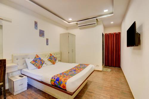 a bedroom with a bed and a television in it at Via 24K Inn - Nr Manipal Hospital in Mundhwa