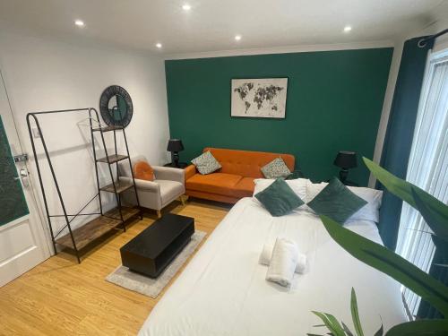 una sala de estar con una cama y un sofá en Rooms in stylish house, en Milton Keynes