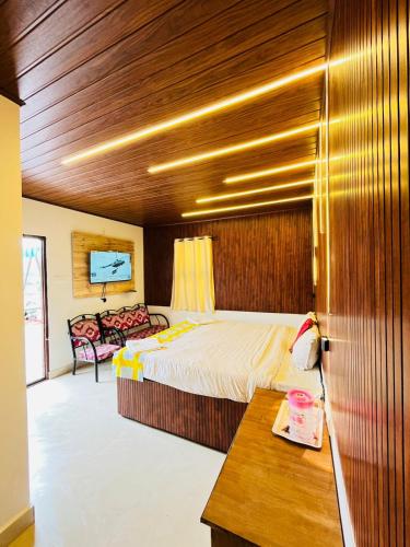 a bedroom with a bed and a table in a room at Coolspot Cottage in Ooty