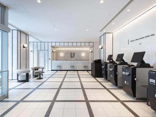 a lobby with desks and chairs in a building at Brackets Hotel Osaka Hommachi in Osaka