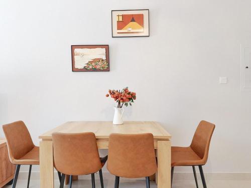 a dining room table with chairs and a vase with flowers at CaiCai Homes AG Tower-Business Bay in Dubai