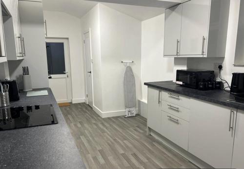 Una cocina con gabinetes blancos y encimera. en Modern ROOM En-Suite Close to Hospital & Train, en Gillingham