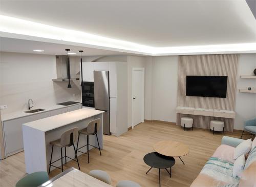 Una cocina y una sala de estar con un sofá y una mesa. en Crescen House, en pleno corazón de Rioja Alavesa, en Baños de Ebro