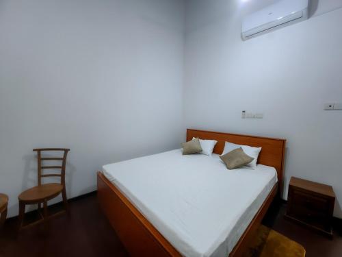 a bedroom with a bed with a chair and a table at Galle Serenity Bliss Private Villa in Galle