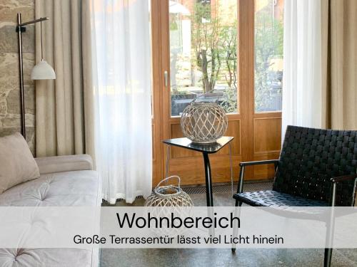 - un salon avec un canapé, une chaise et une fenêtre dans l'établissement HexenburgbeiDresden Stylishes Designerappartement mit Schlafsofa, Terrasse - Nähe Sächsische Schweiz Dresden, à Großharthau