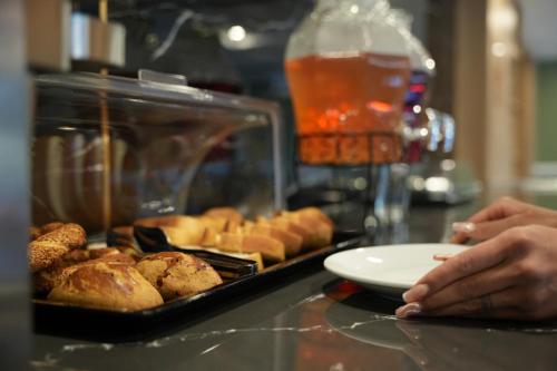 un tavolo con un vassoio di prodotti da forno e un piatto di cibo di Kent Room Hotel a Kapaklı