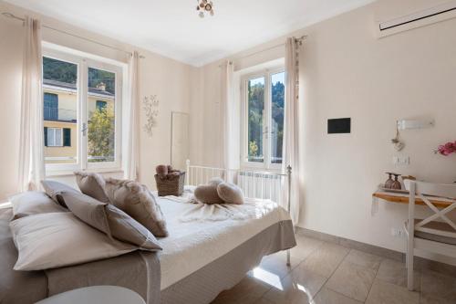 a white room with a bed and two windows at La Rosa Dei Venti in Vernazza