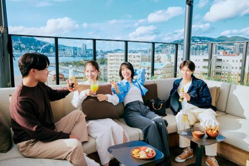 a group of people sitting on a couch with drinks at FAV LUX Nagasaki in Nagasaki
