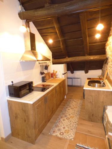 a kitchen with wooden cabinets and a microwave at Casa Luna de La Viliella in La Viliella