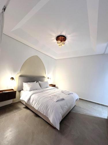 a bedroom with a white bed with a ceiling at Dar Fatma Charming Moroccan Guesthouse with Pool & Hammam in Sidi Bibi
