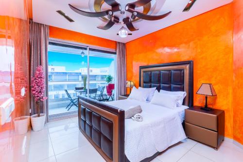 a bedroom with a large bed and a balcony at Vue mer, piscine & plage à vos pieds in Aourir