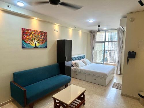 a living room with a couch and a bed in it at Serene LakeView Studio Apartment at Hiranandani Estate, Thane in Thane