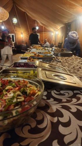 een buffet lijn met veel borden eten op een tafel bij Aka luxury camp in Merzouga