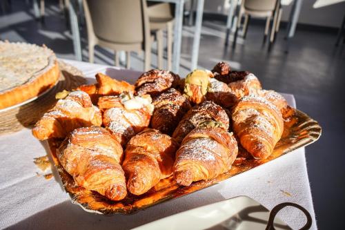 - un plateau de croissants et d'autres viennoiseries sur une table dans l'établissement Eolia Rooms, à Lipari