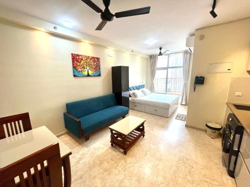Una sala de estar con un sofá azul y una mesa. en Picturesque LakeView Studio Apartment Hiranandani Estate Thane, en Thane