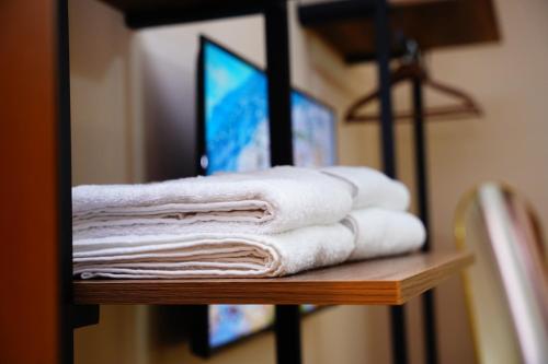 a pile of towels sitting on a shelf in a bathroom at Vila 15 By Nam Nam Tirane in Tirana