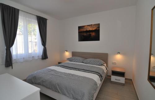 een slaapkamer met een groot bed met 2 kussens bij Apartments Kankul in Krk